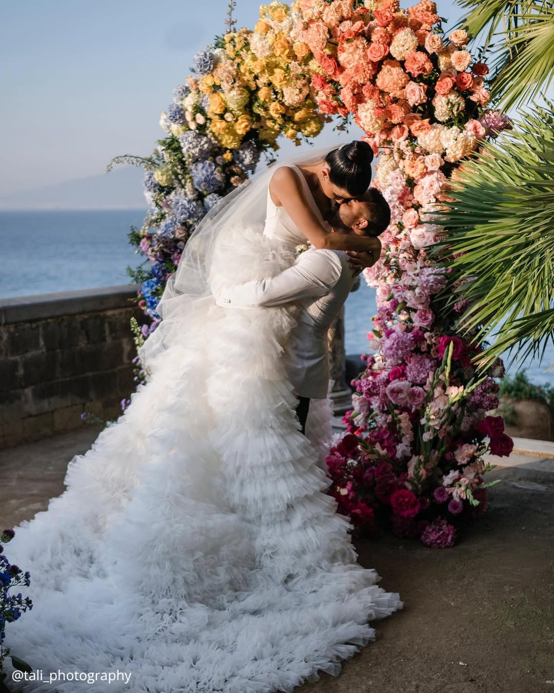 wedding photos happy brides under a bright color arch ceremony tali photography