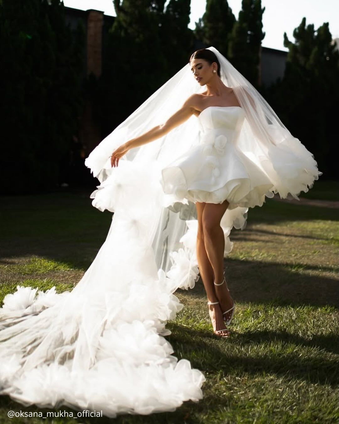 wedding photos happy beautiful bride in a short dress standing on green grass oksana mukha official