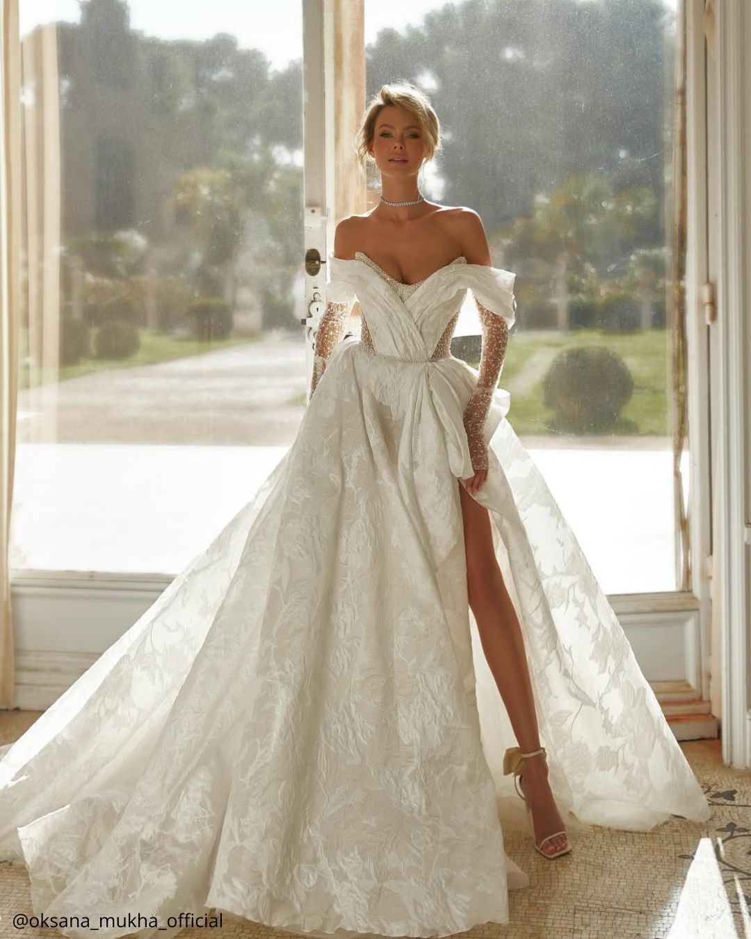 wedding photos happy beautiful bride in a dress with a whirlpool standing by the window oksana mukha official