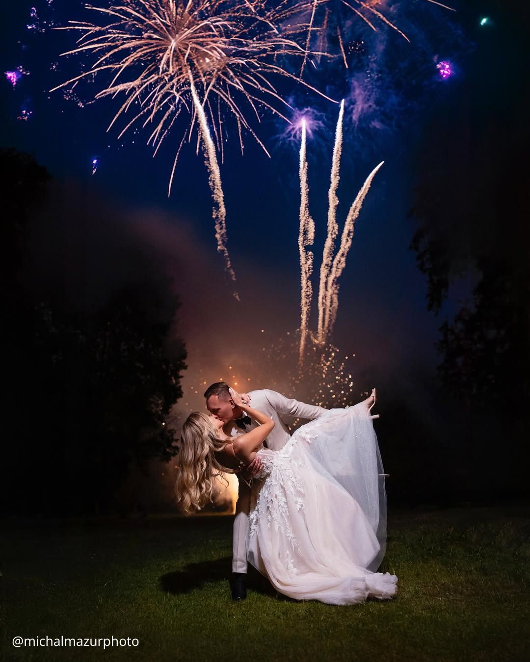 wedding photos magical night kiss of brides on the background of fireworks he holds her michalmazurphoto