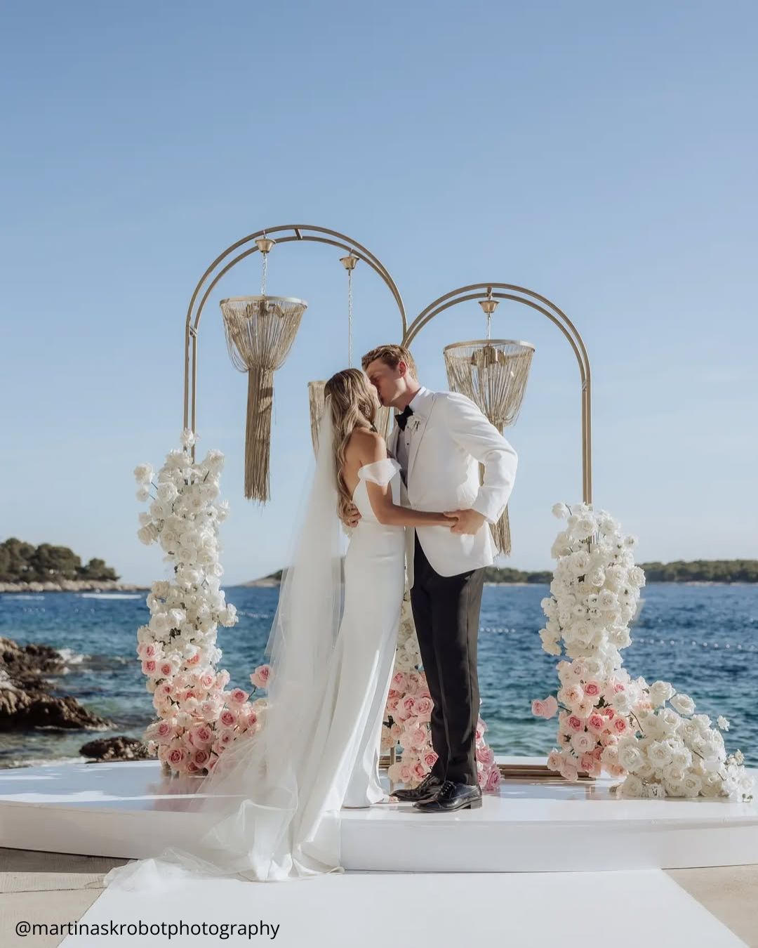 wedding photos happy brides at the ceremony kissing against the sea background martinaskrobotphotography