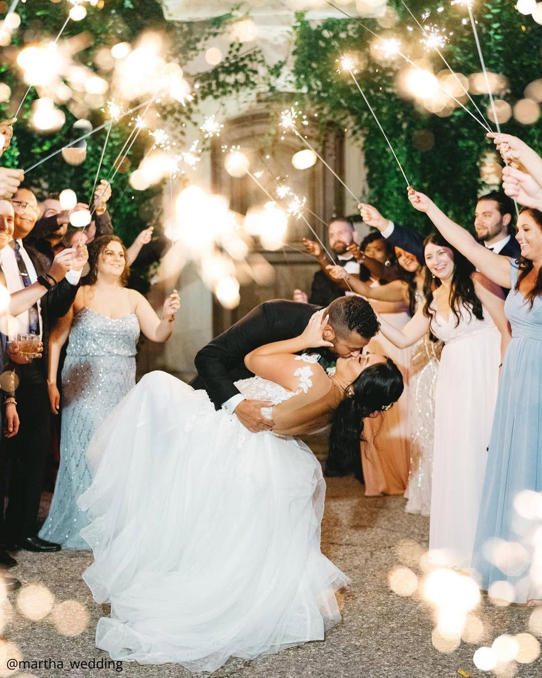 wedding photos happy brides kissing under the lights guests holding the lights martha wedding