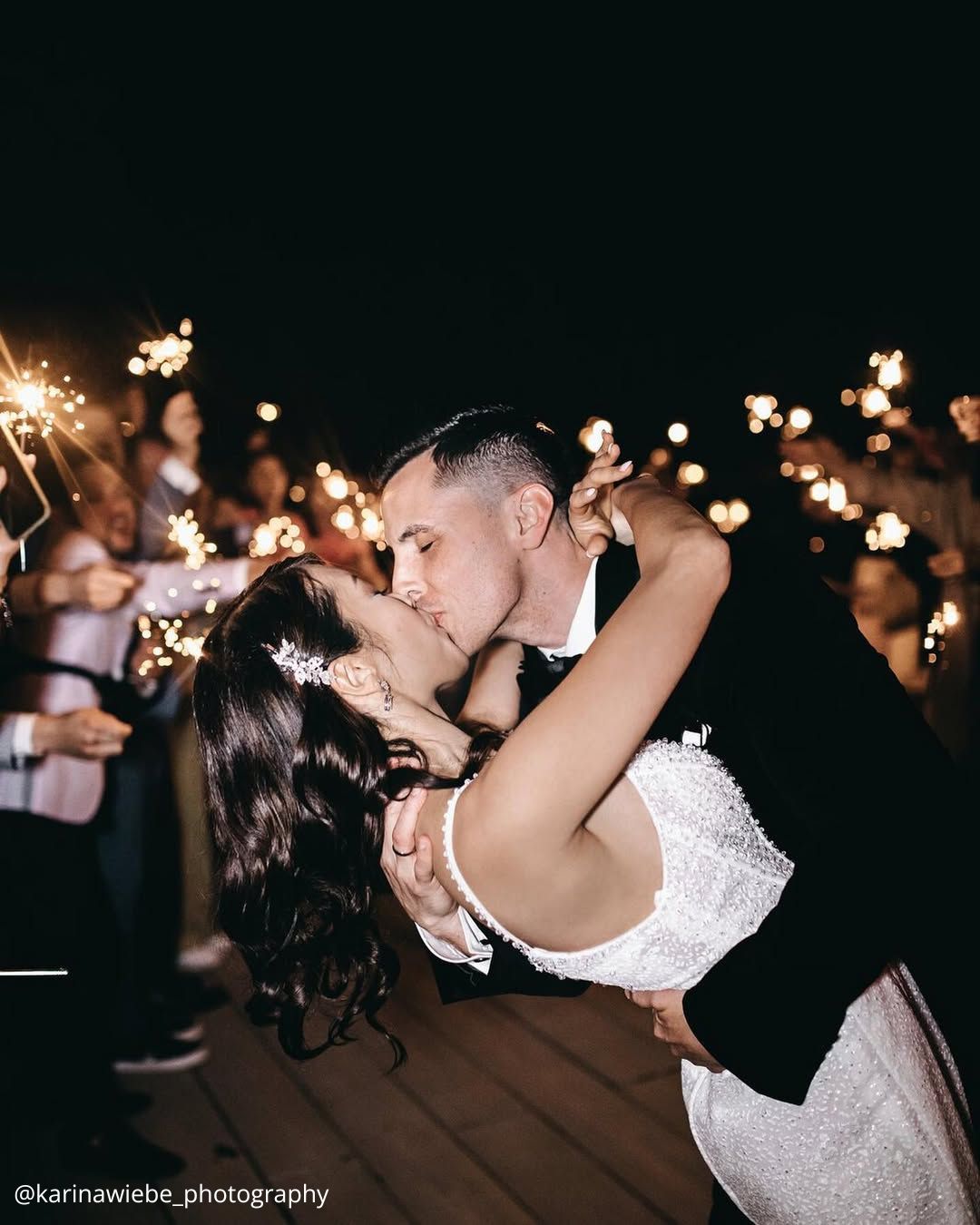 wedding photos happy brides kissing under the lights guests holding lights evening karinawiebe photography